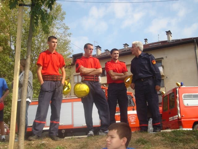 Članovi u vatrogasnim odorama ispred vatrogasnih vozila
