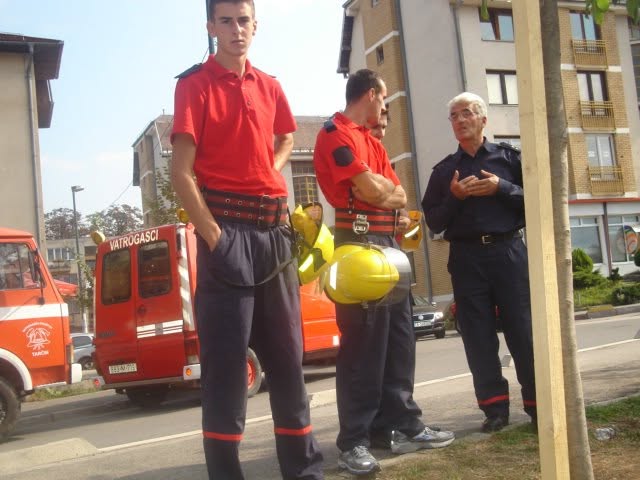Vatrogasci razgovaraju pokraj vozila s natpisom Vatrogasci